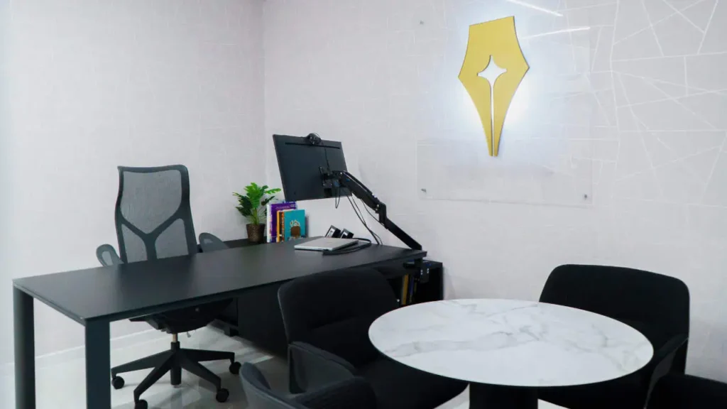 Dream Writers office desk with computer and company logo on the wall